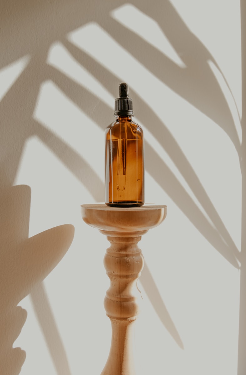 gold and black bottle on white wooden table